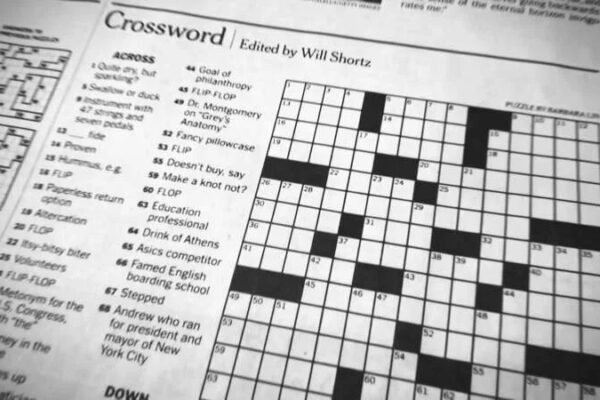 A jar of sauerkraut, a popular sauer condiment, with the New York Times crossword puzzle in the background.